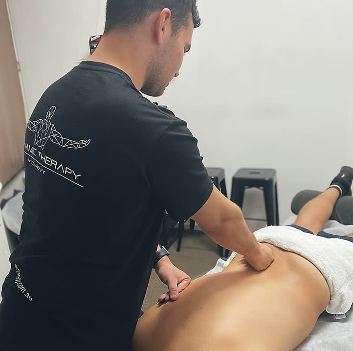 Dynamic Therapy myotherapist using his forearm to release a client's lower back during a hands-on treatment session